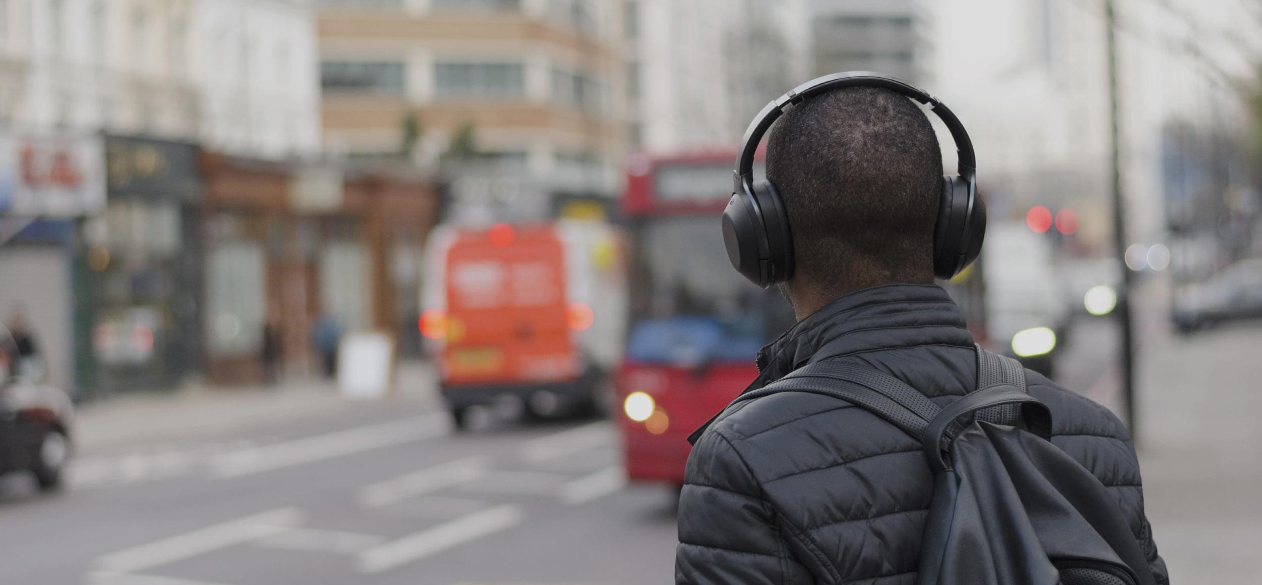 Man wearing headphones looking out on to the street